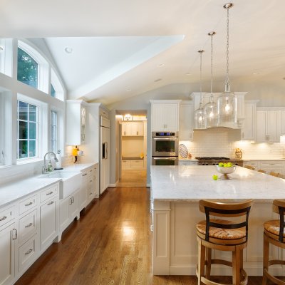 Long kitchen counter with dormer ceiling and large arched windows