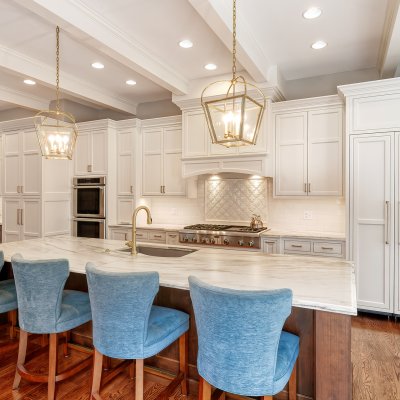 kitchen with white cabinets, white backsplash, and large island