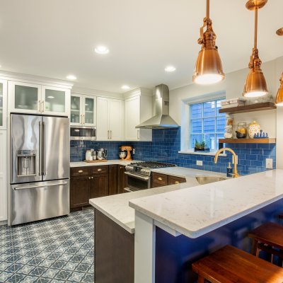 Renovated kitchen with tile floor and copper light fixtures   