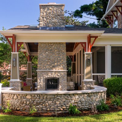 outdoor covered living area with double-sided stone chimney and fireplace