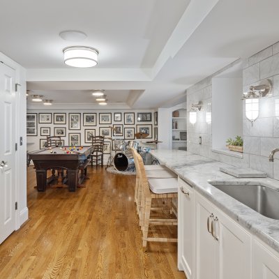 renovated basement kitchenette white cabinets pool table