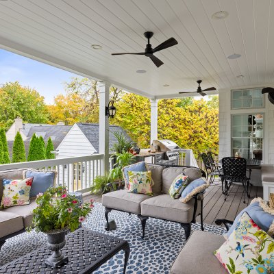 covered outdoor living space with ceiling fans, TV, grilling area black metal furniture